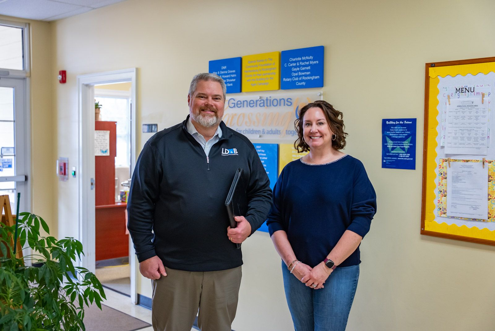 older gentleman from LD&B insurance standing and smiling with the executive director of Generations Crossing